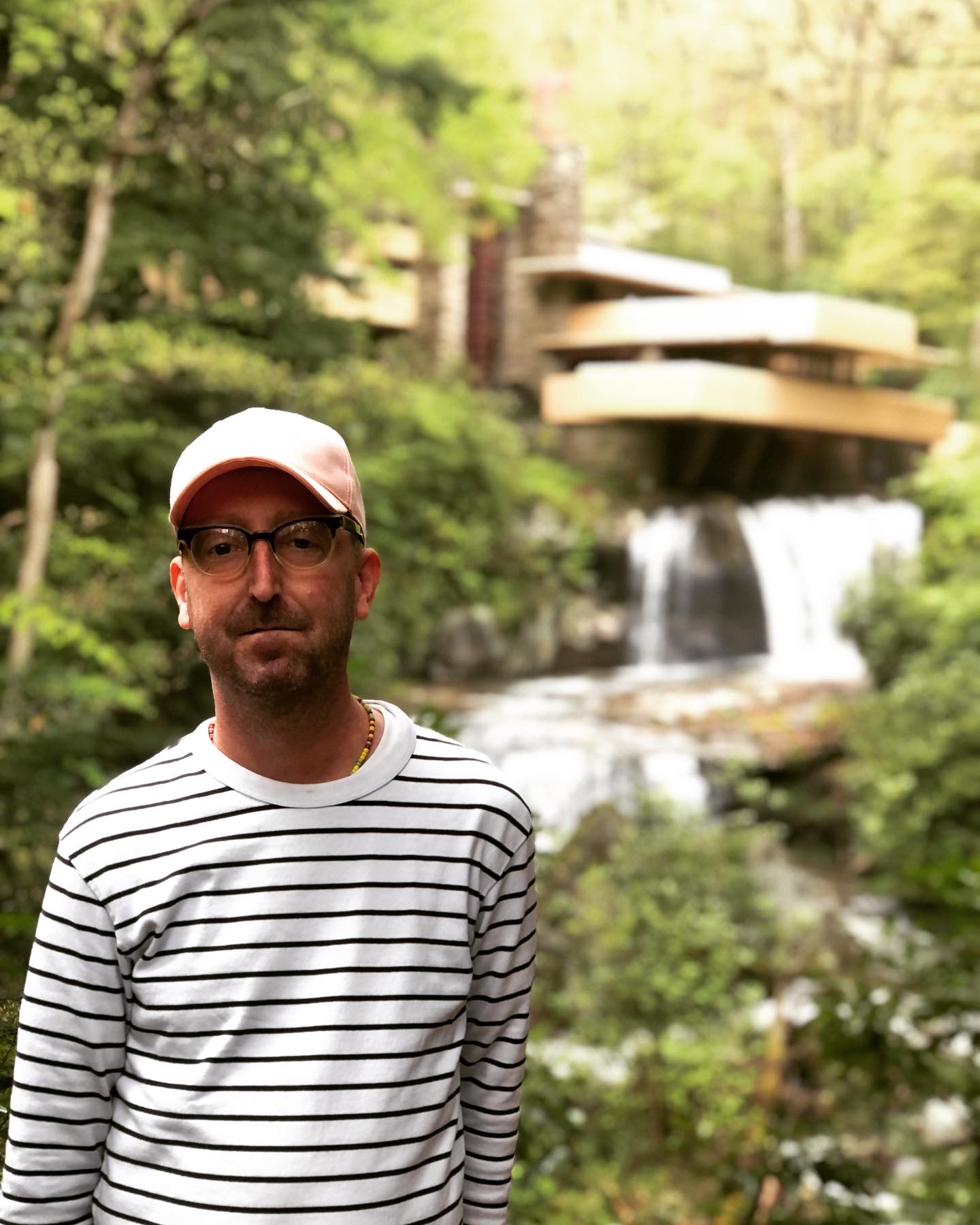 Artist Jared Phillips outdoors beside a waterfall
